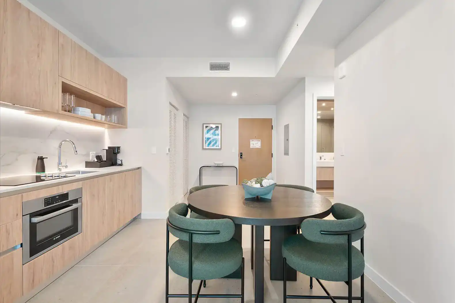 Modern kitchen with dining area featuring a round table and stylish chairs