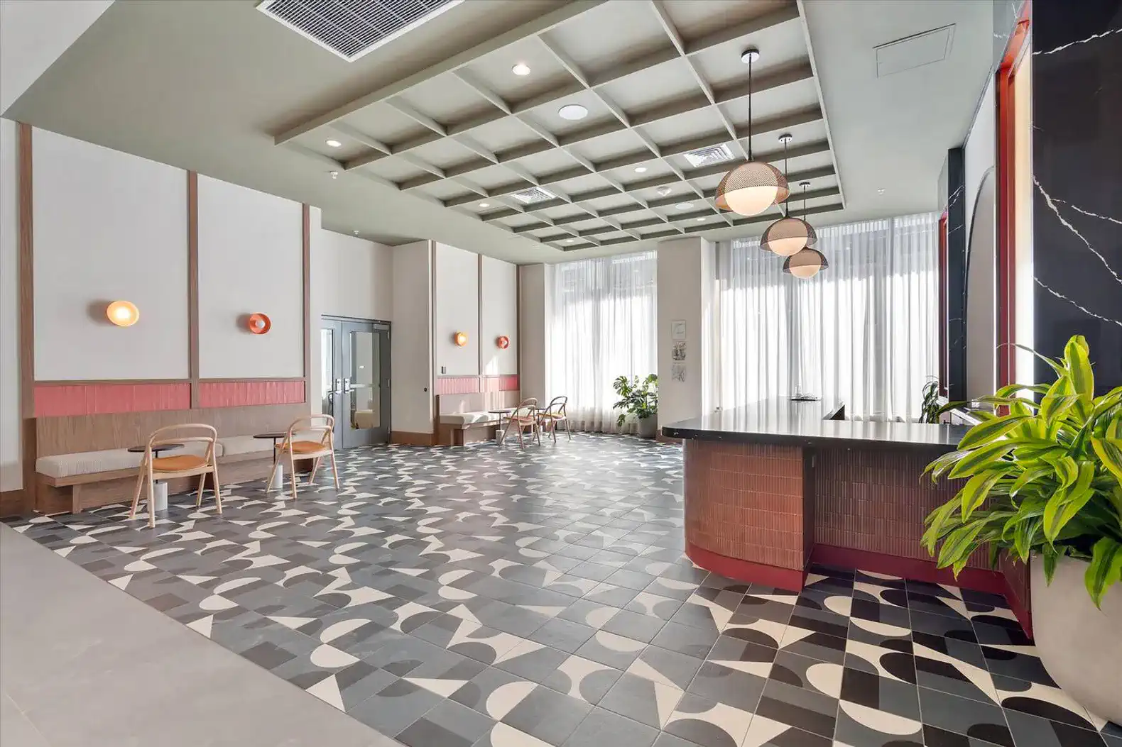 Spacious lobby area with modern decor, patterned flooring, and large windows