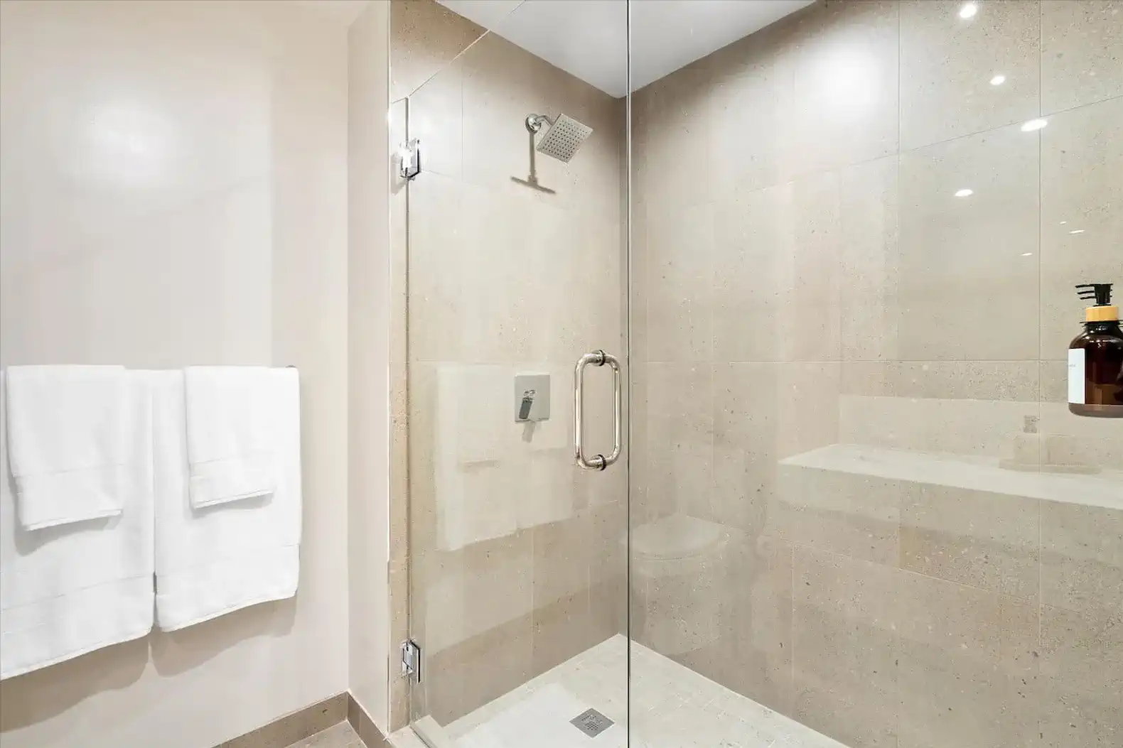 Modern glass shower with stone tiles and sleek fixtures