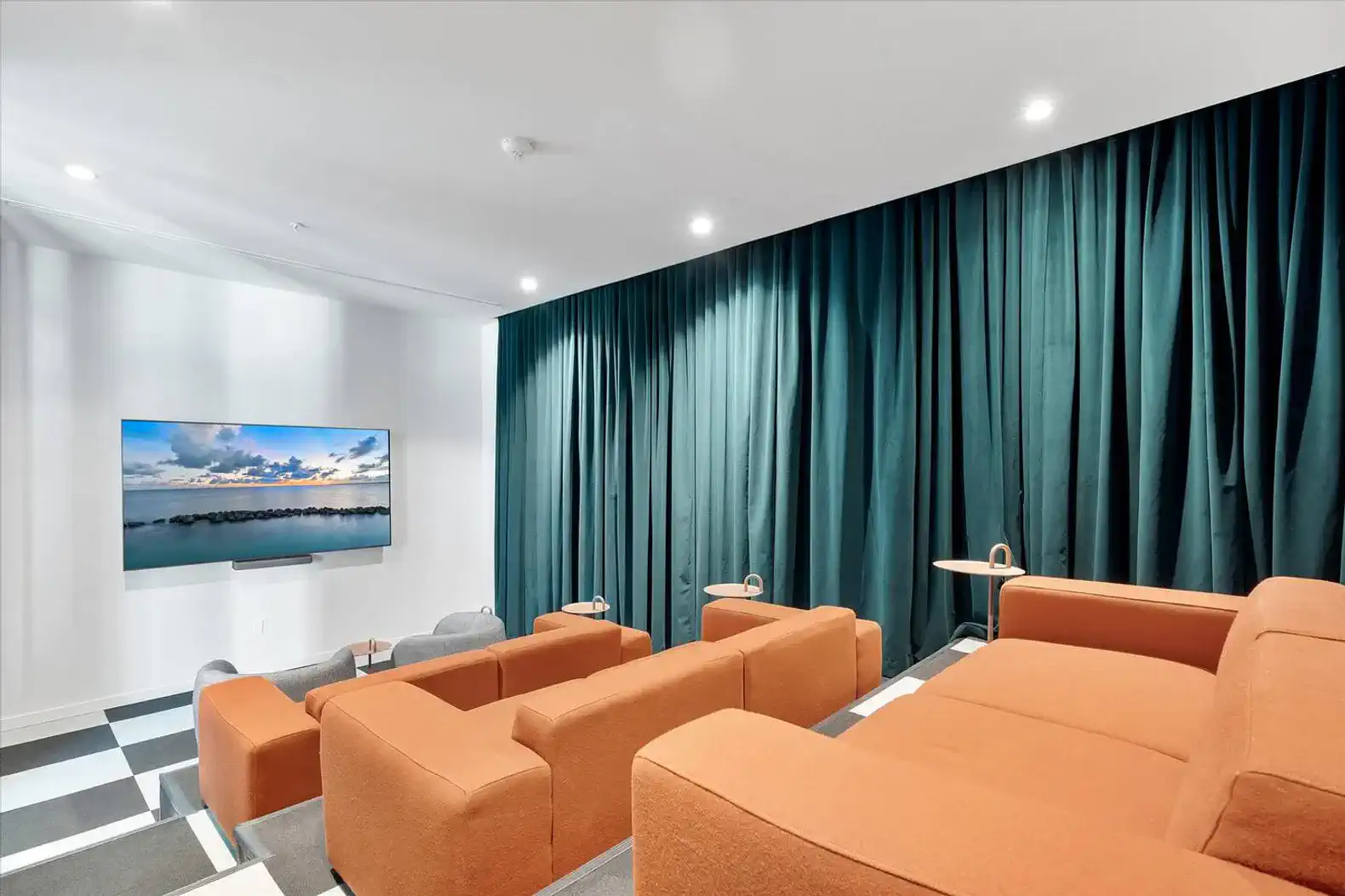 Cozy media room with orange sofas and a large screen for entertainment