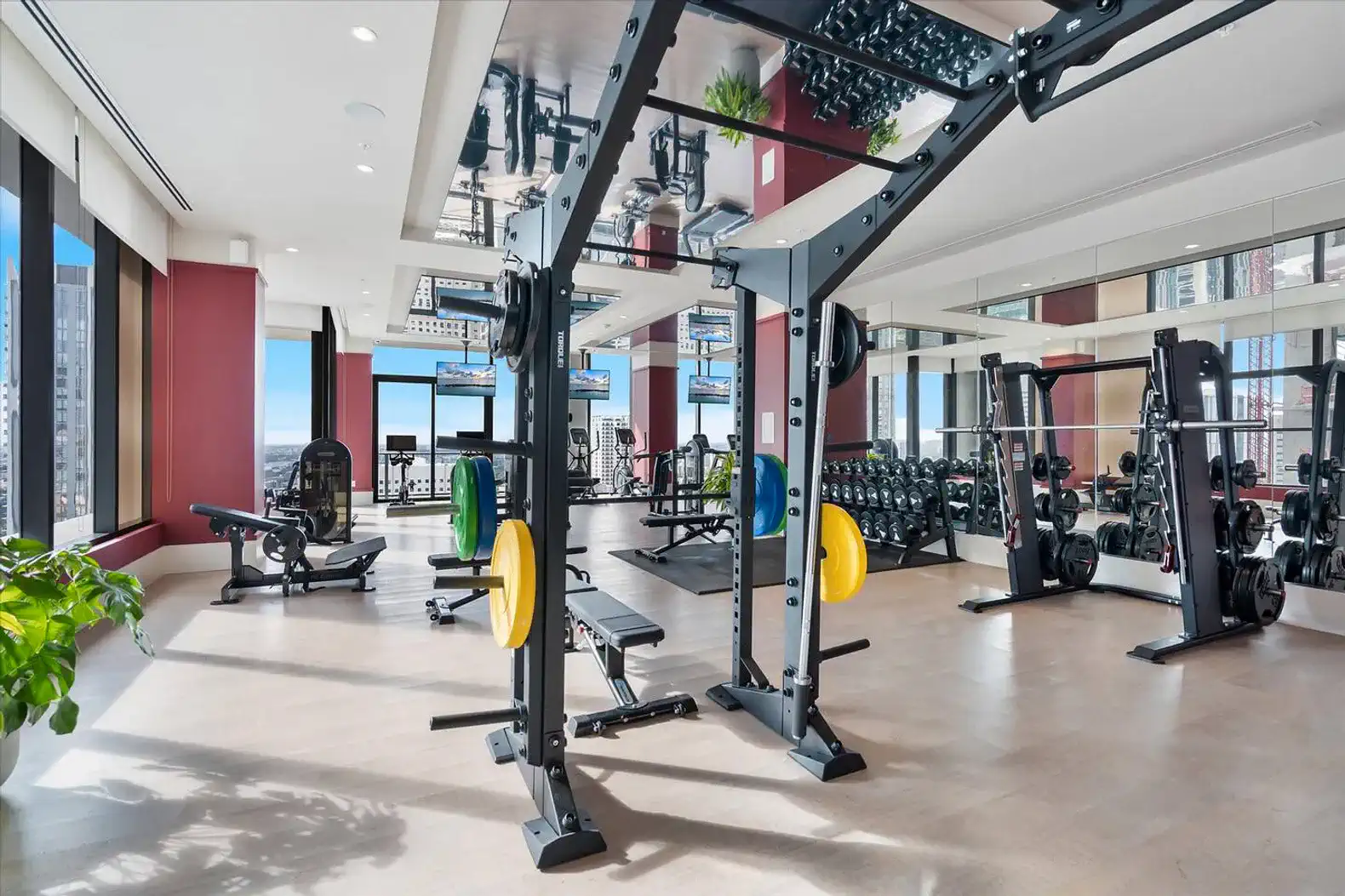 modern gym with weightlifting equipment and large windows offering city views