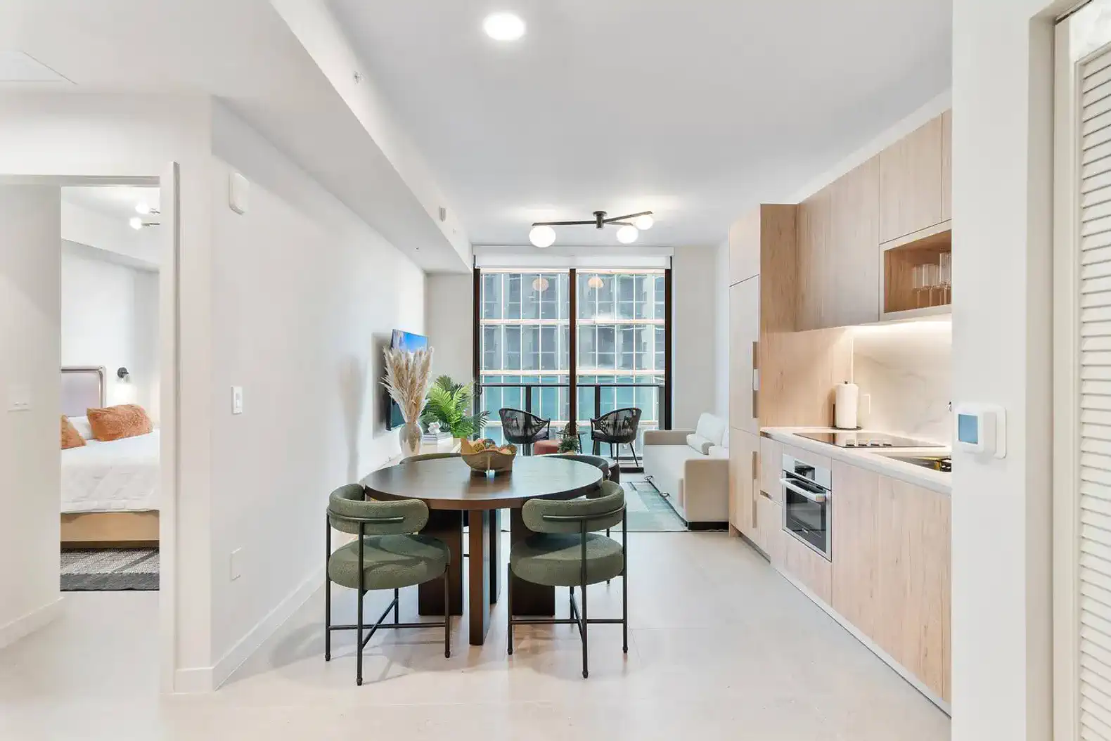 Modern dining area with a round table and stylish chairs, open to the kitchen and living space