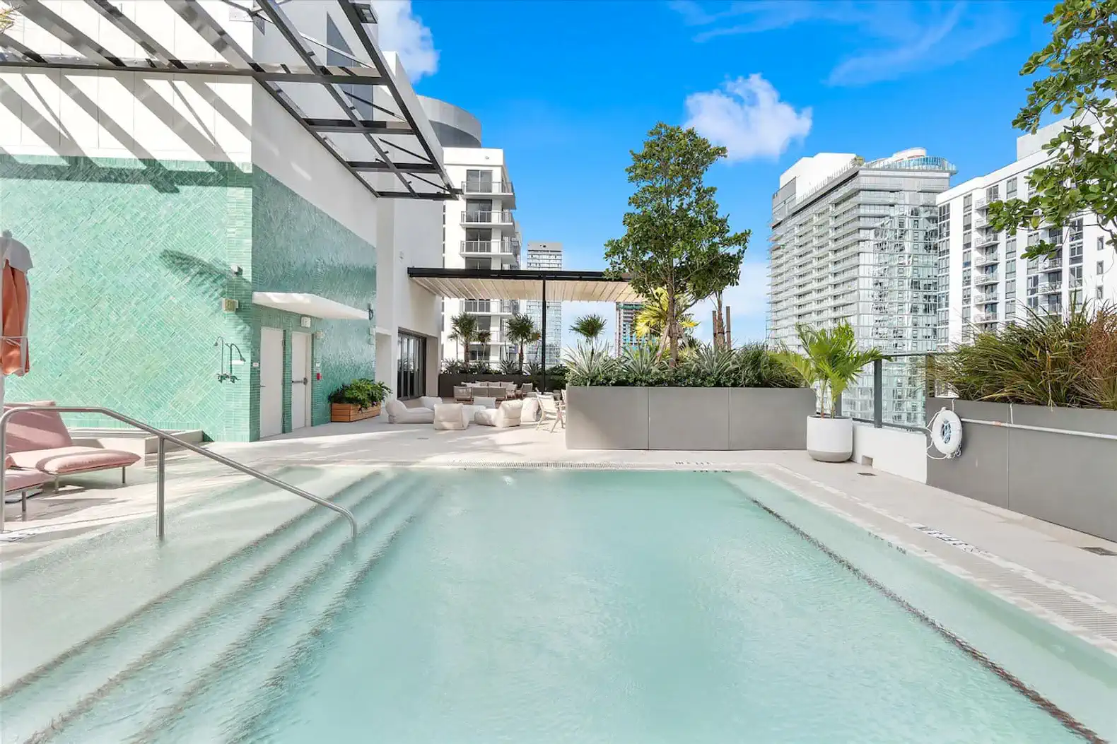 Stylish pool area with modern lounge seating and city views