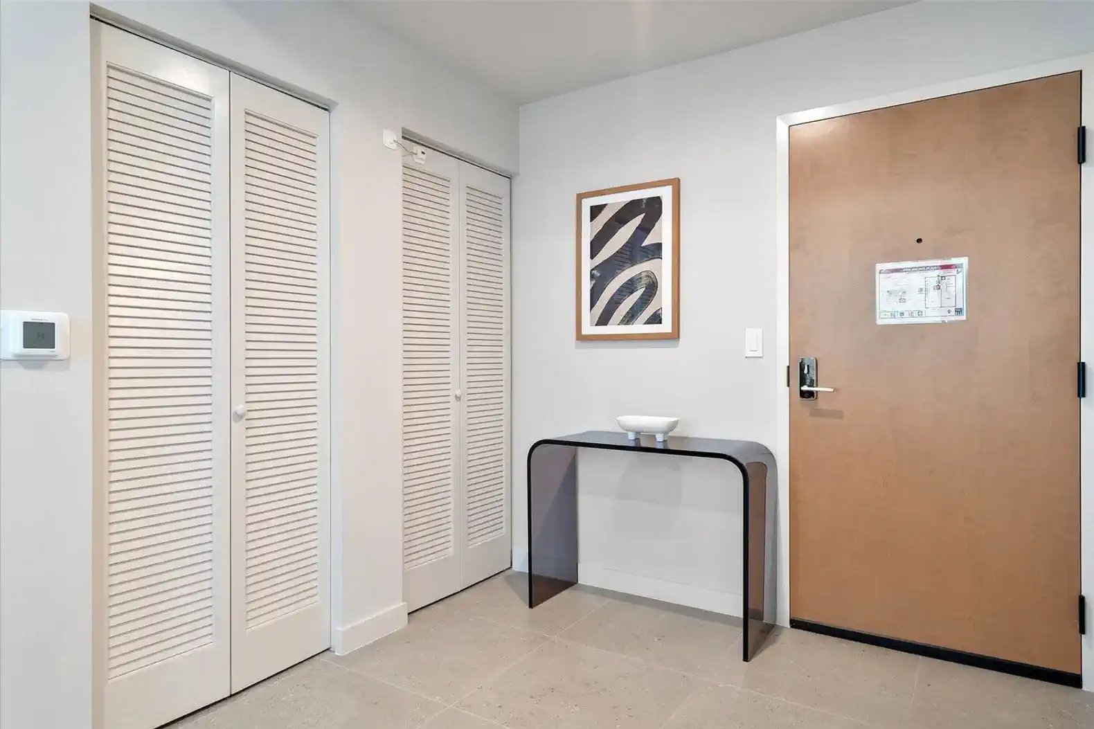Modern entrance with a sleek console table and closet doors