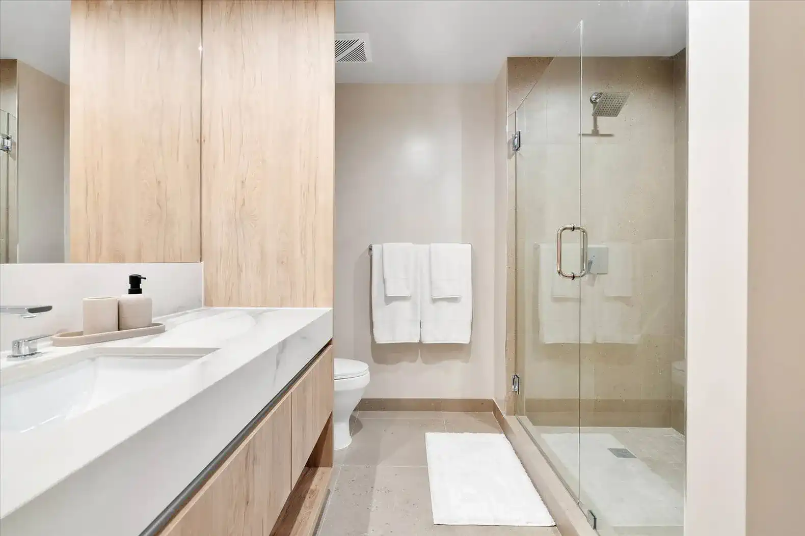 Modern bathroom featuring a glass shower, sleek cabinetry, and neutral tones