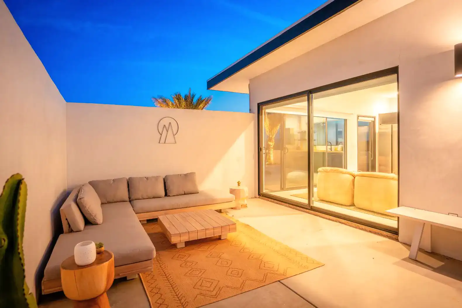 Cozy outdoor seating area with a rug and modern decor under a twilight sky