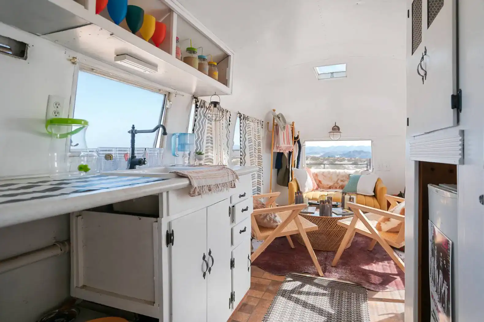 Cozy living area with a kitchenette and seating, large windows showcasing desert views