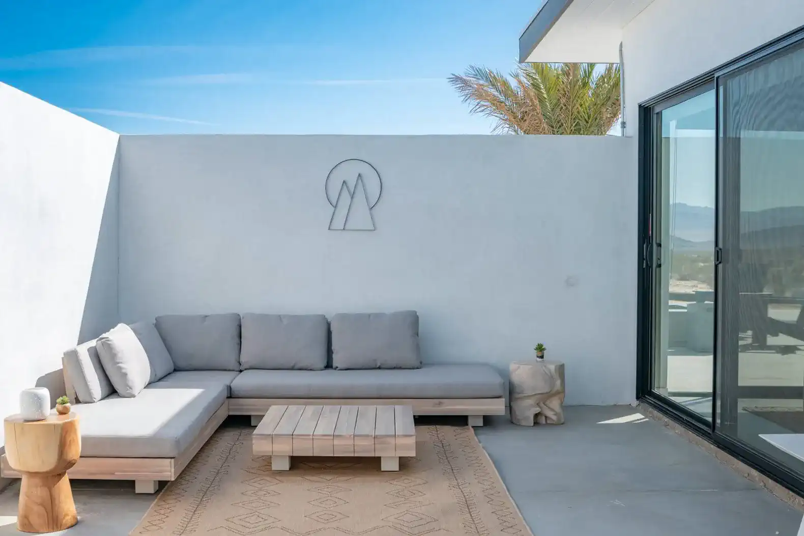 Cozy outdoor seating area with a sectional sofa and coffee table against a desert backdrop