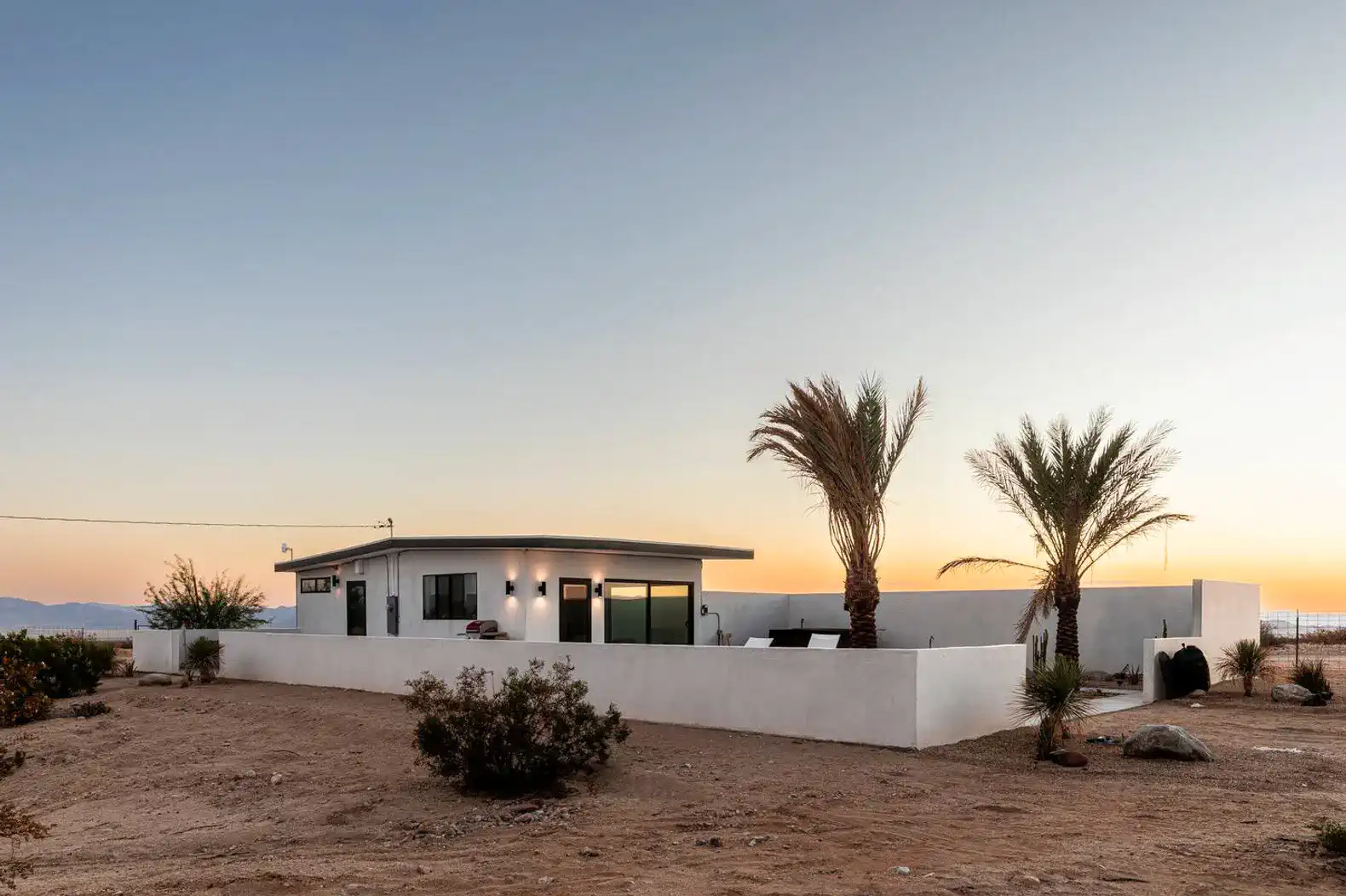 Desert home with palm trees and sunset view