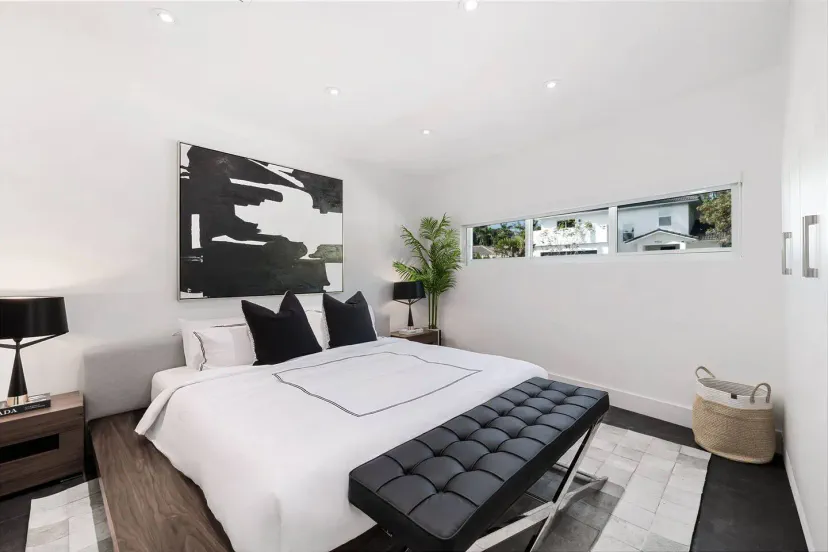 King size bedroom with built-in closet and a Smart TV mounted on the wall 