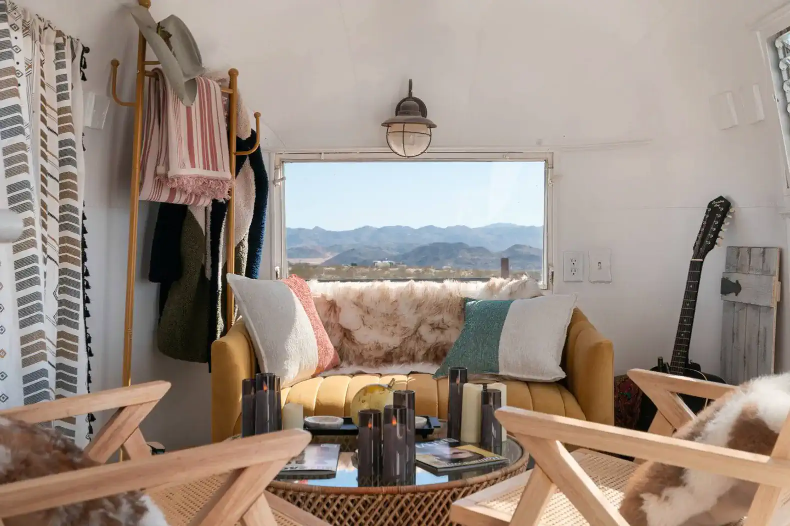 Cozy living area with a yellow sofa, mountain views, and decorative accents