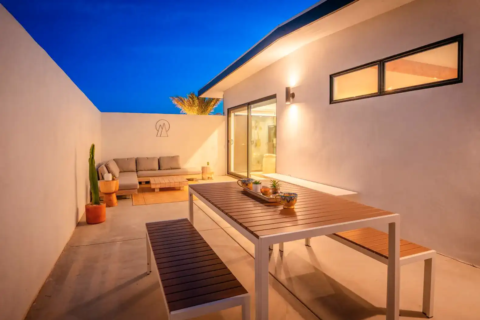 Outdoor seating area with a table and benches under a clear blue sky