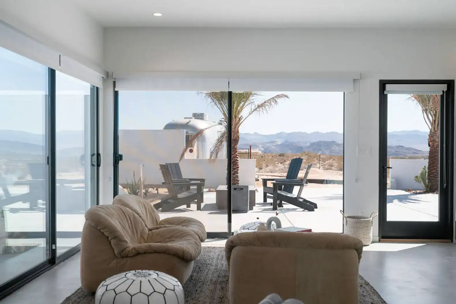 Spacious living area with large windows showcasing desert views and outdoor seating