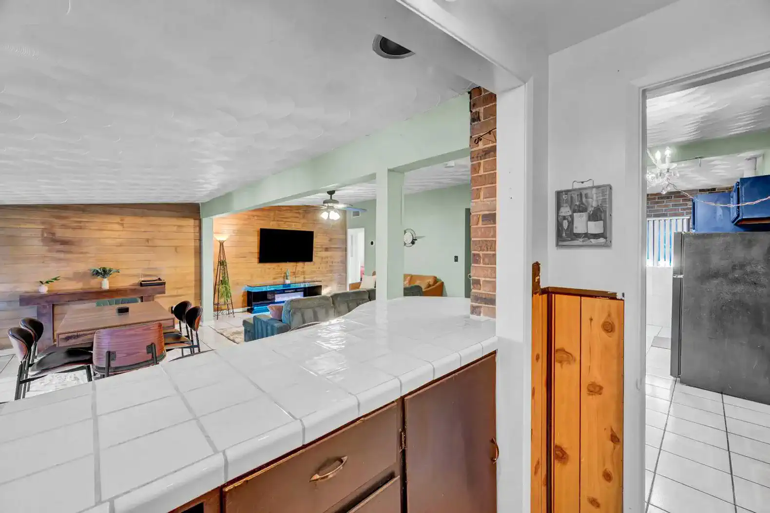 Open kitchen view with bar counter overlooking the living area and dining space