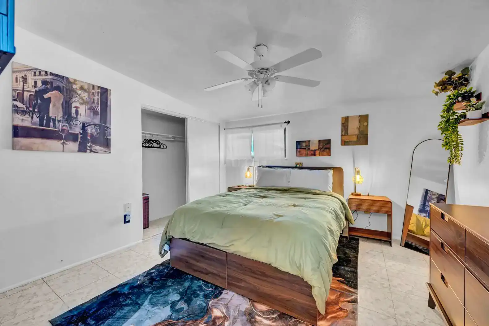 Cozy master bedroom with a queen bed, ceiling fan, and artwork on the walls