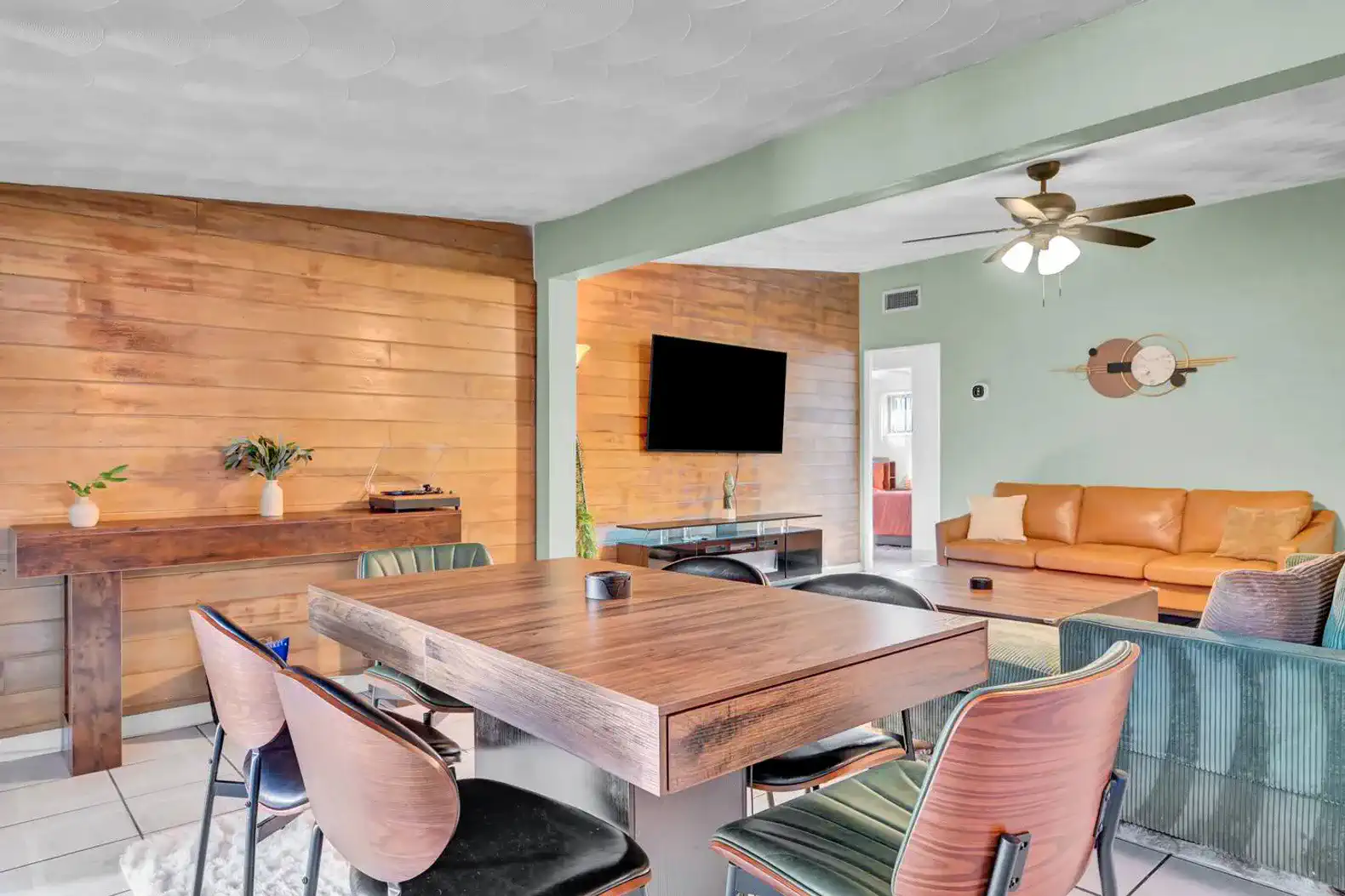Spacious dining area with wooden table and stylish chairs adjacent to a cozy living room