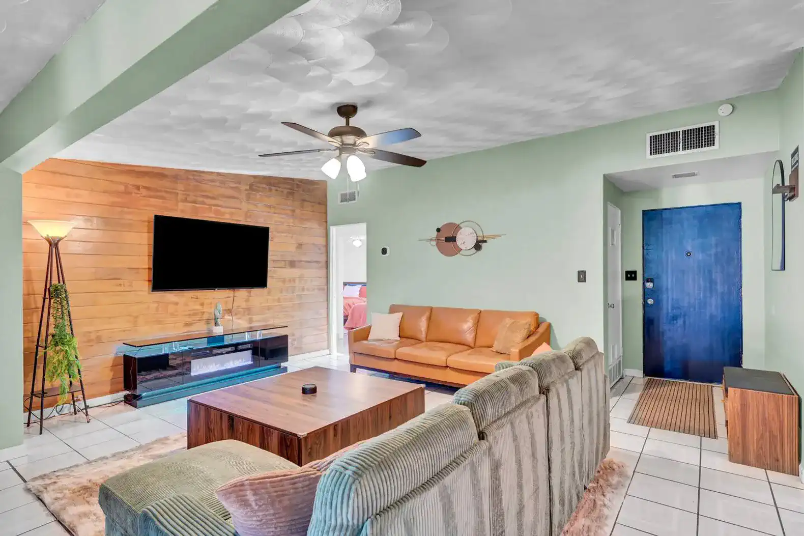 Spacious living room with a leather sofa, wooden accents, and a flat-screen TV