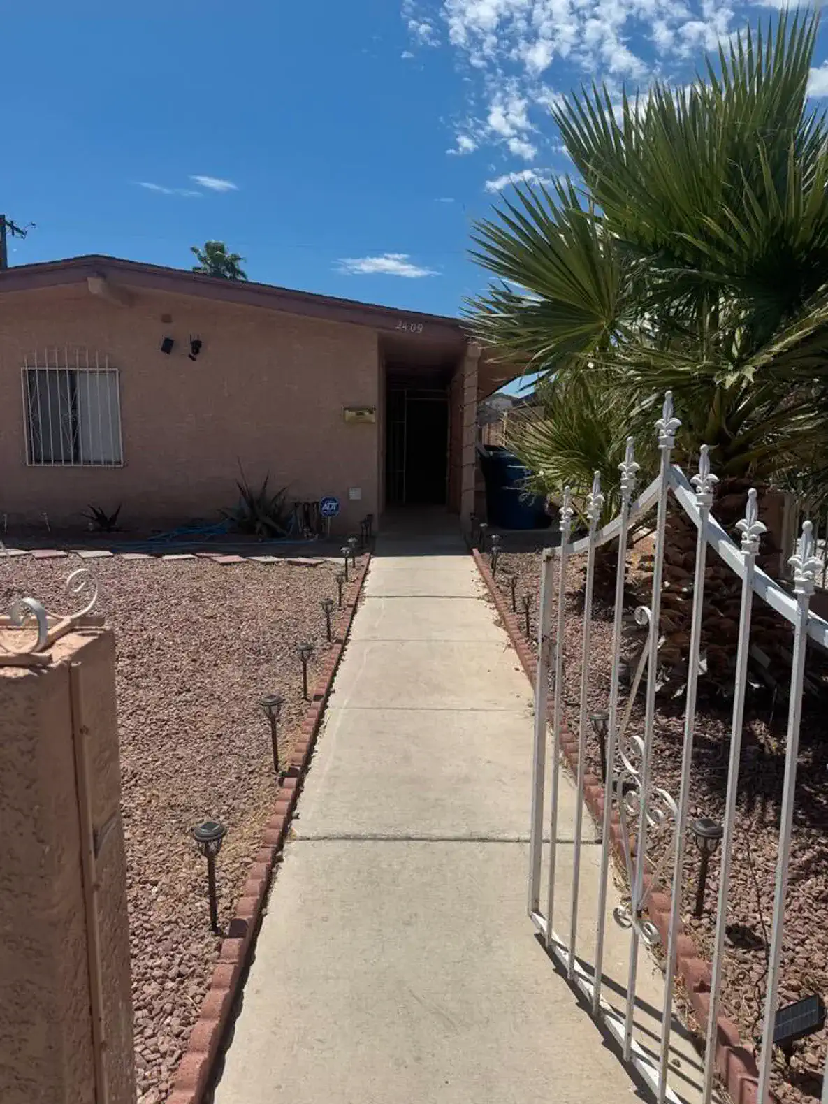 Pathway leading to the entrance with desert landscaping and palm trees