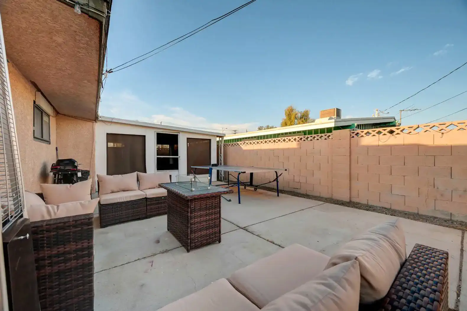 Spacious outdoor patio area with seating and a ping pong table