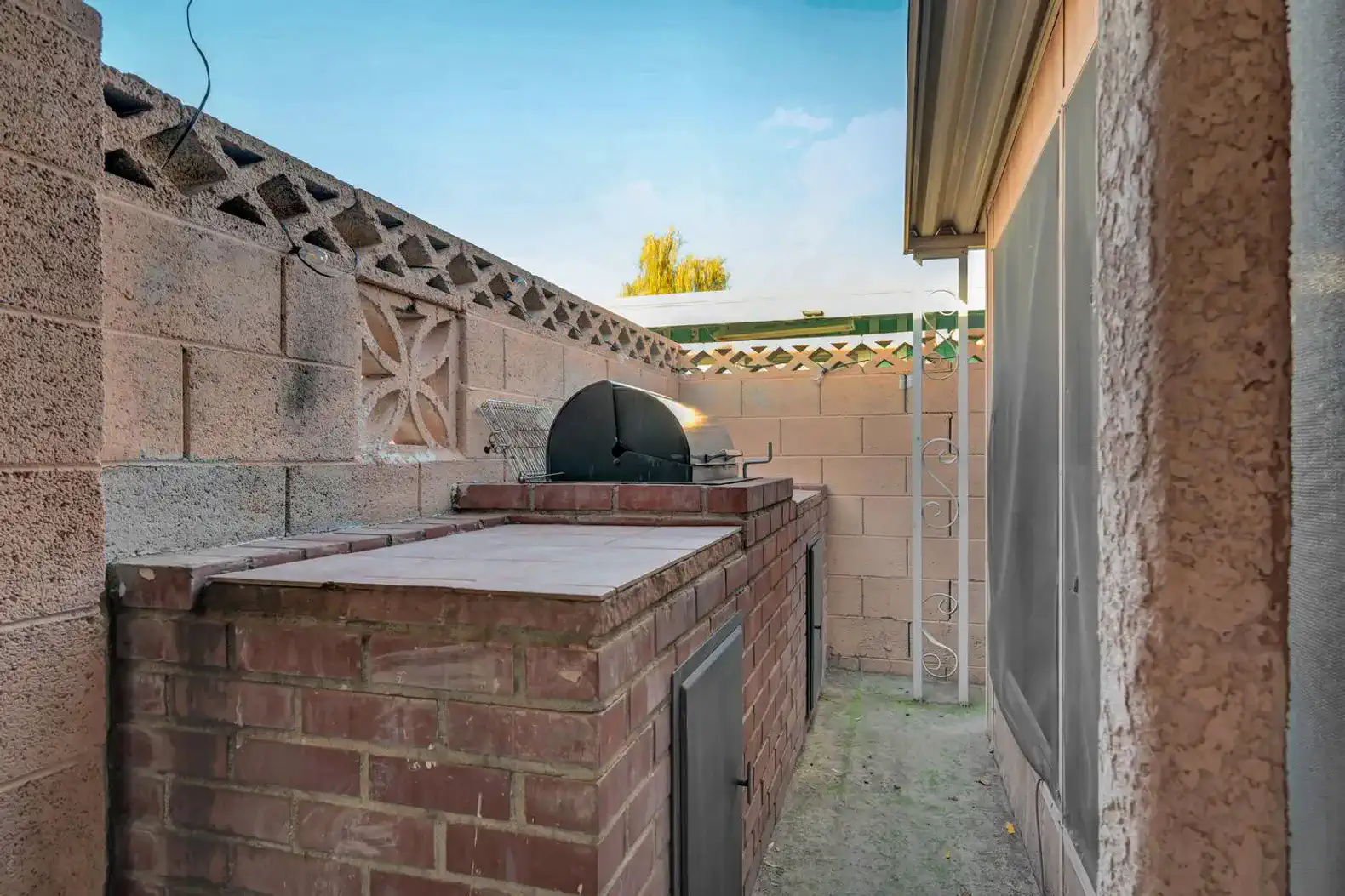 Brick BBQ grill area with surrounding walls and outdoor space
