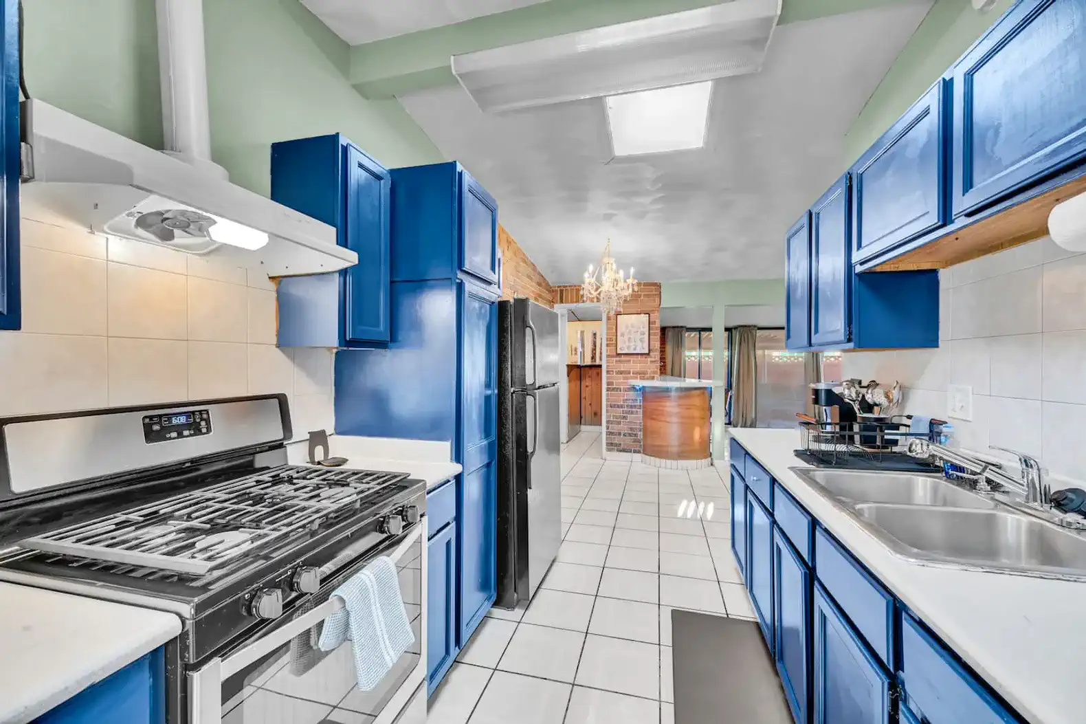 Bright kitchen with blue cabinets, gas stove, and open layout