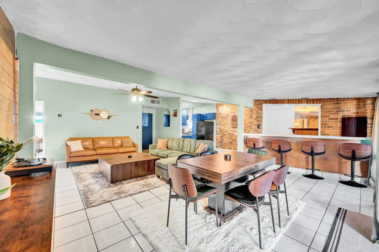 Spacious living area with seating, dining table, and open kitchen view