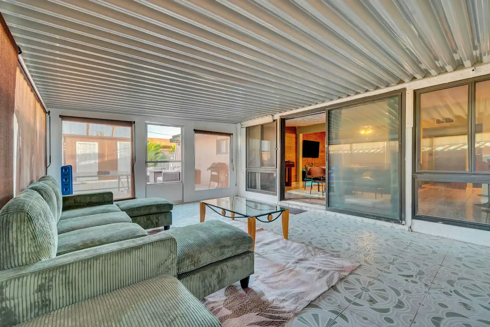 Spacious screened-in patio with comfortable seating and tile flooring