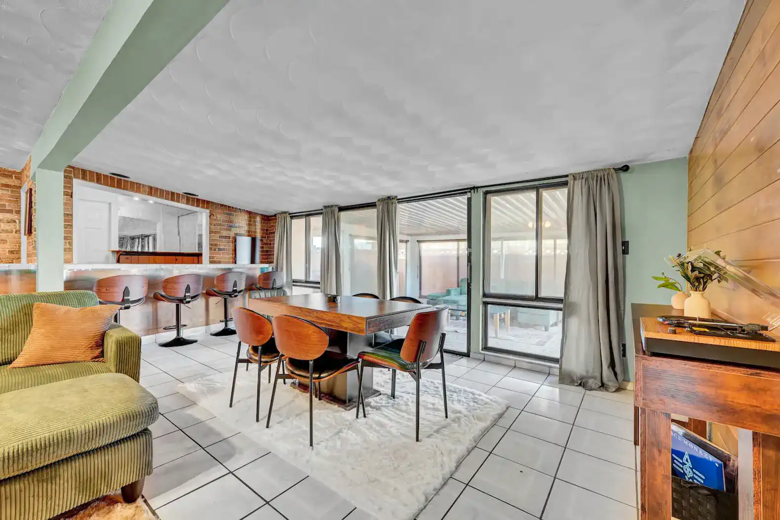 Spacious dining area with modern furniture and large windows overlooking an outdoor space