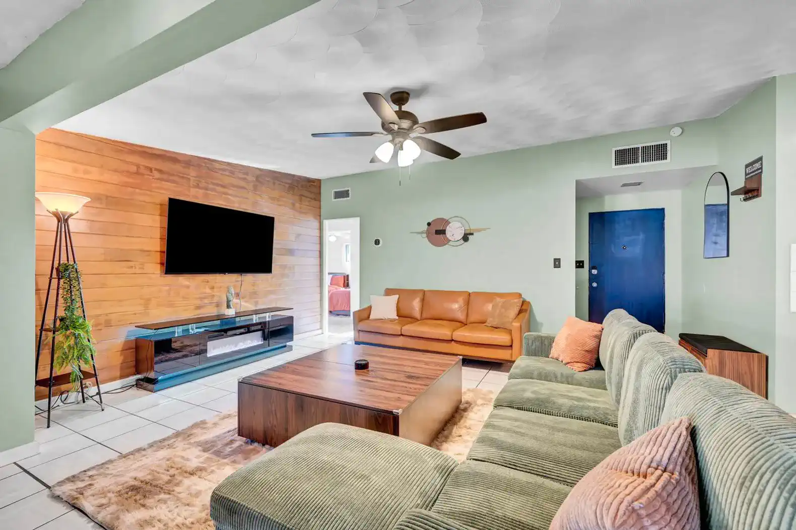 Spacious living room with sectional sofa, wooden accent wall, and modern decor