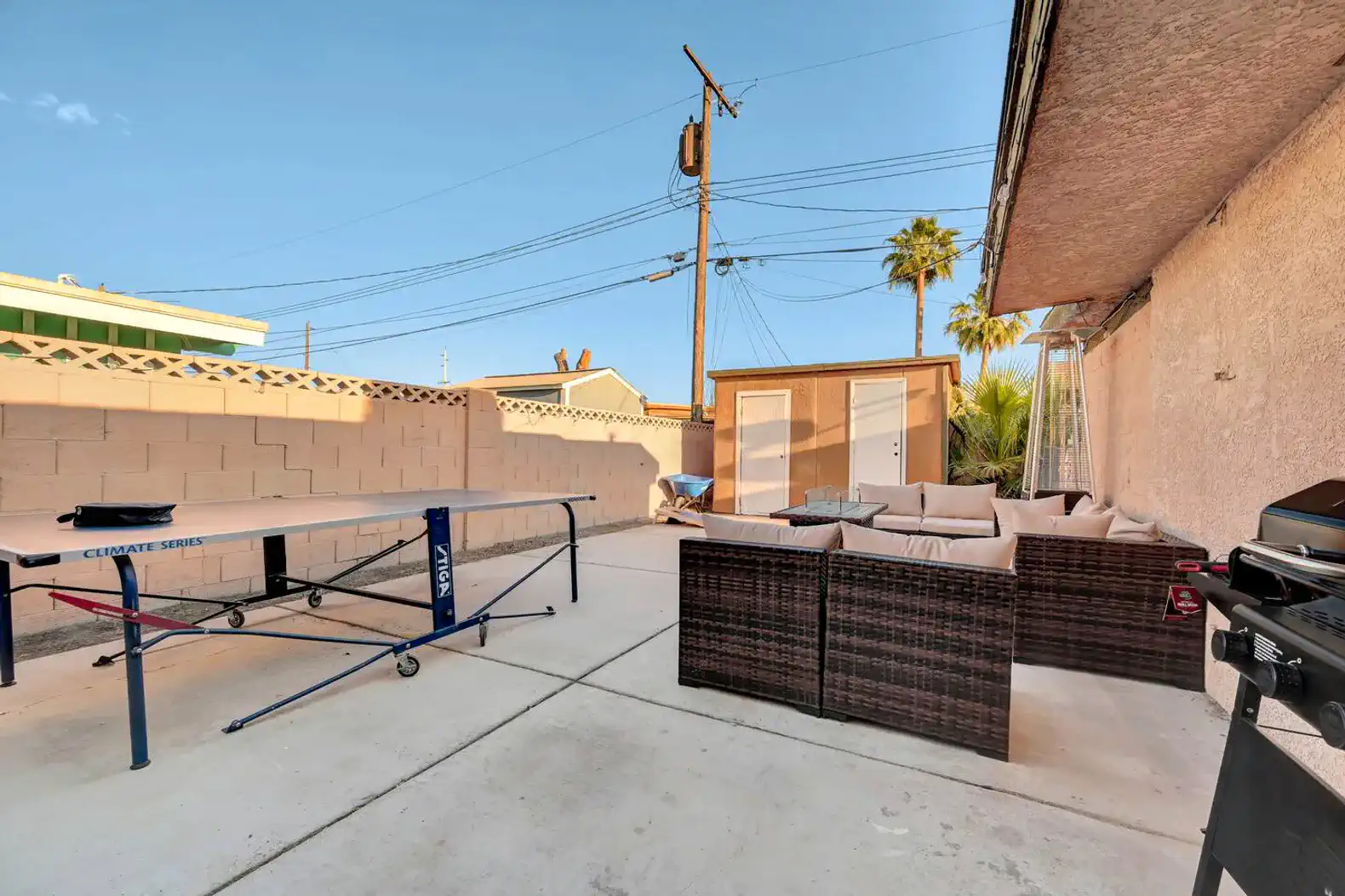 Outdoor patio area with seating and a ping pong table