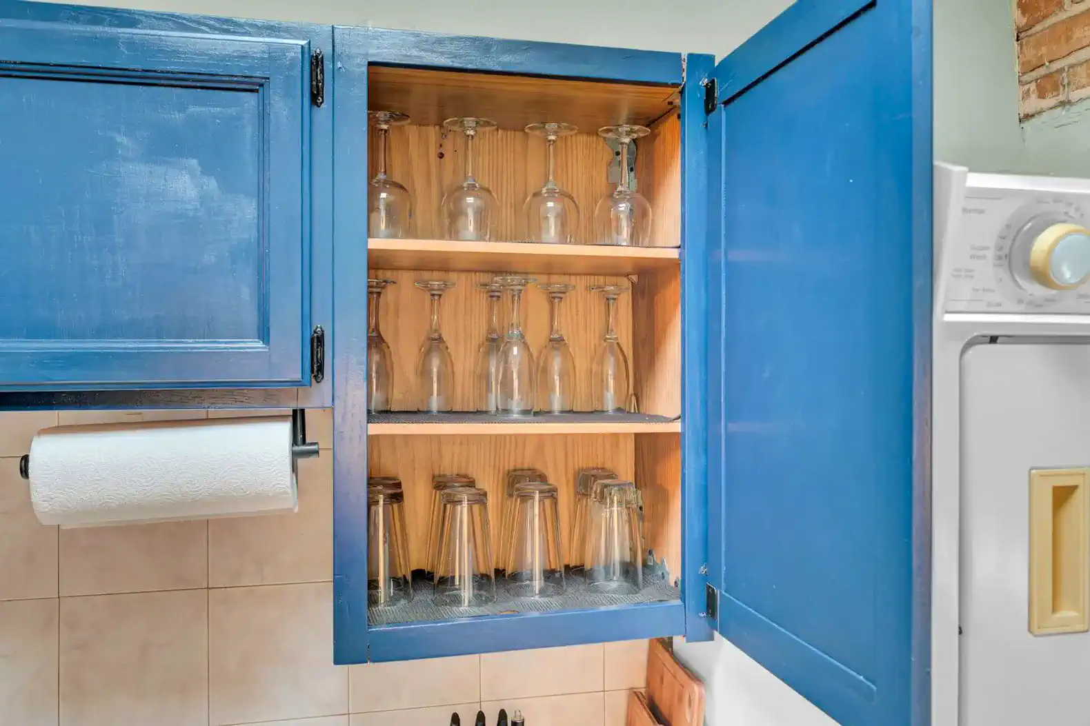 Blue cabinet with glassware and wine glasses neatly arranged inside