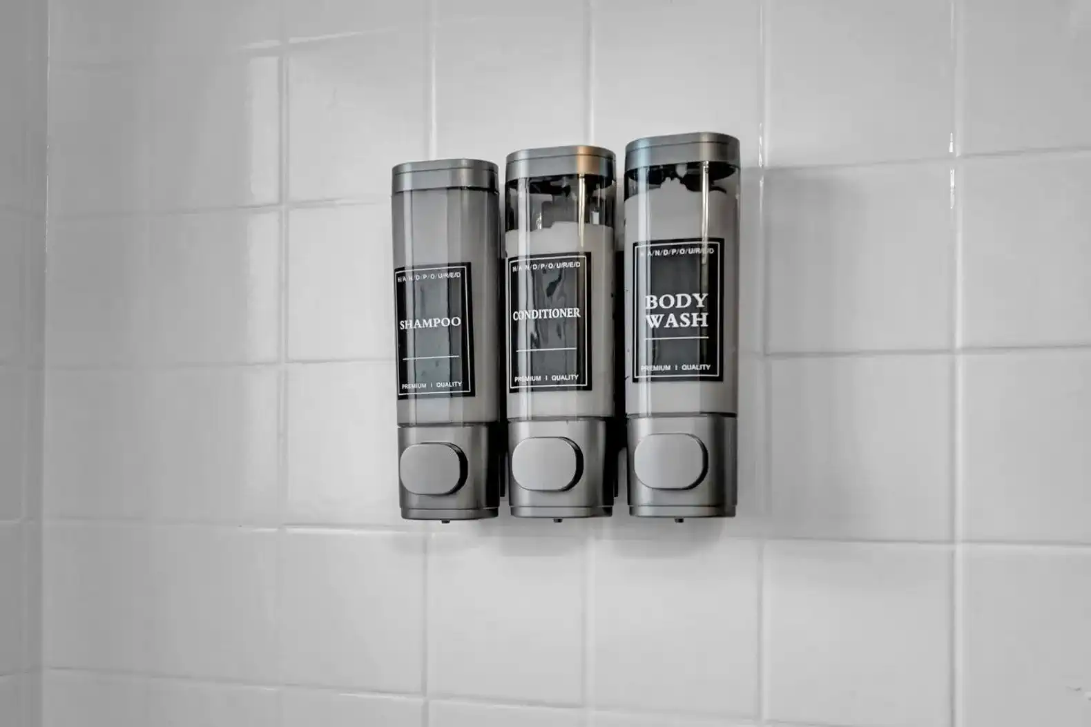 Wall-mounted dispensers for shampoo, conditioner, and body wash in a shower