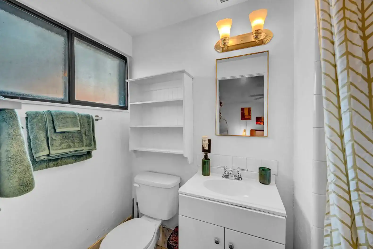Bright bathroom with modern fixtures and green towels
