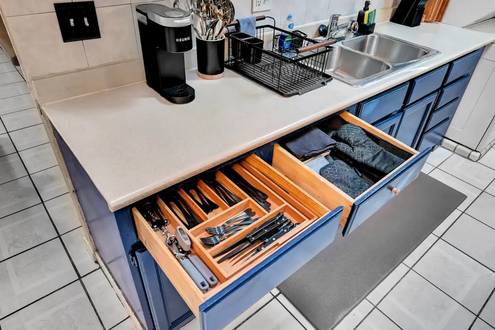 Well-organized kitchen drawers with utensils and dish towels