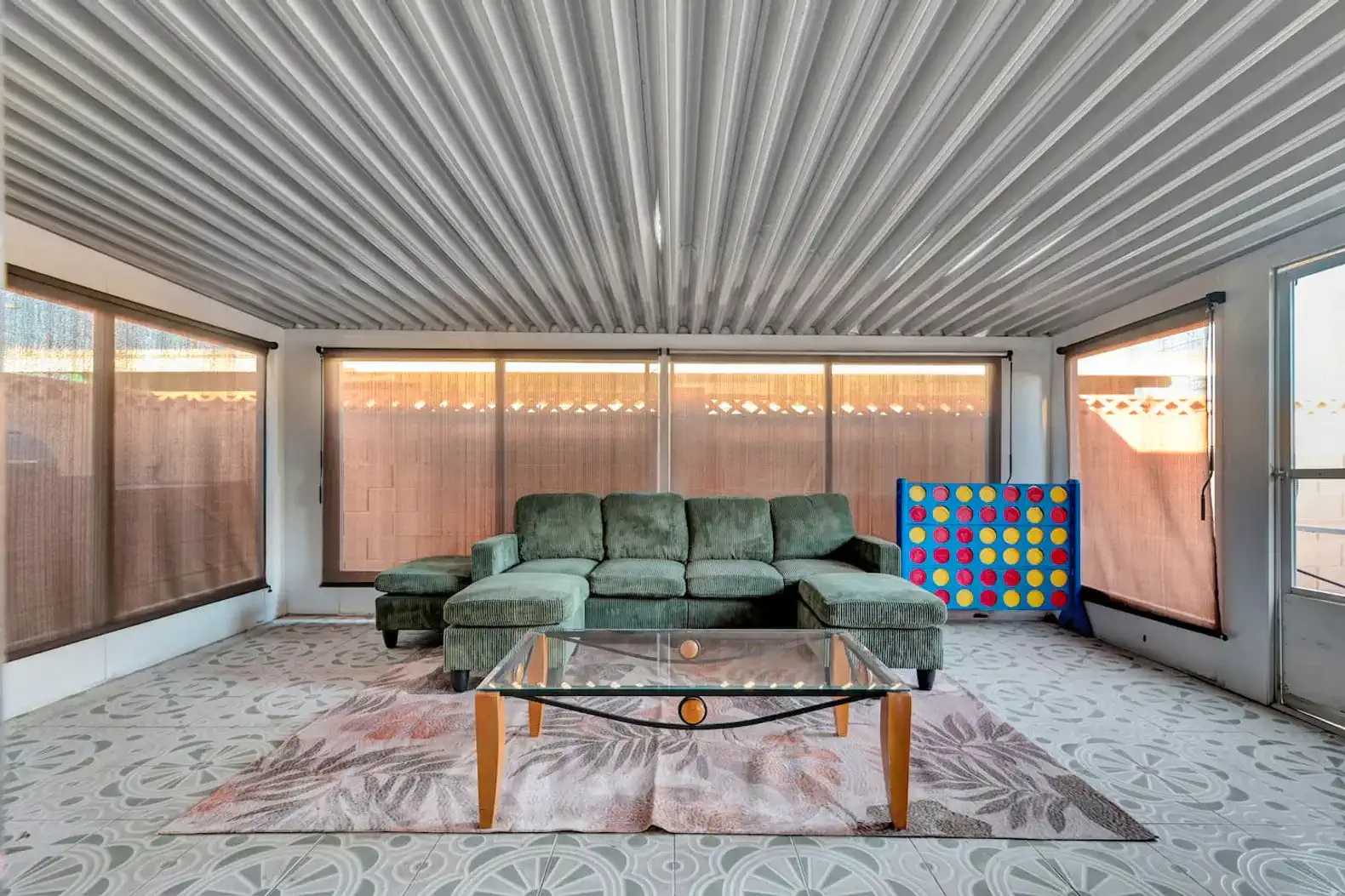 Spacious indoor lounge area with green sectional sofa and large windows