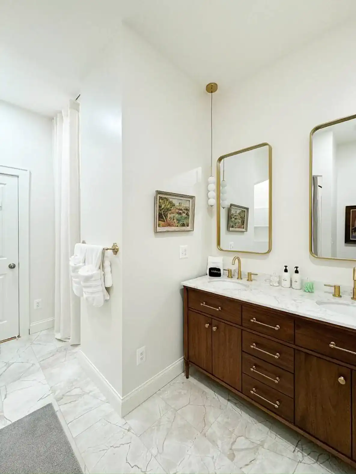 Elegant bathroom featuring dual sinks, marble countertops, and modern fixtures