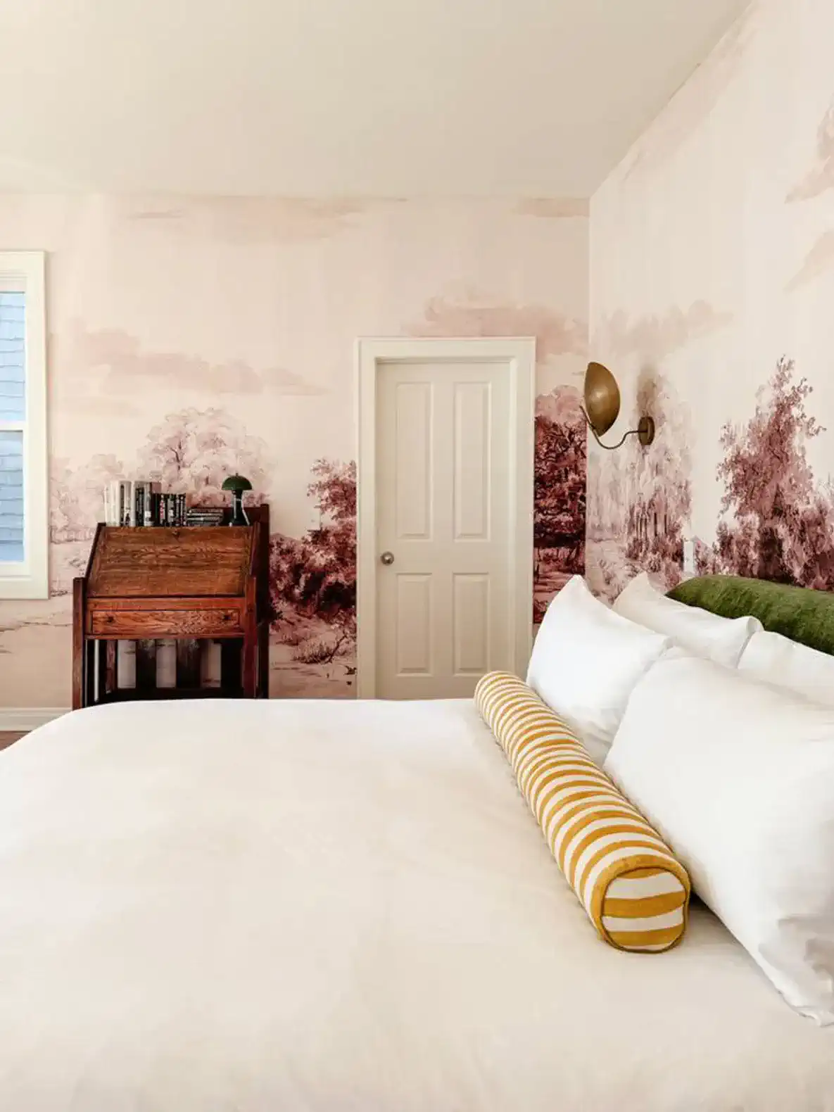 Cozy master bedroom with a scenic mural and a vintage writing desk