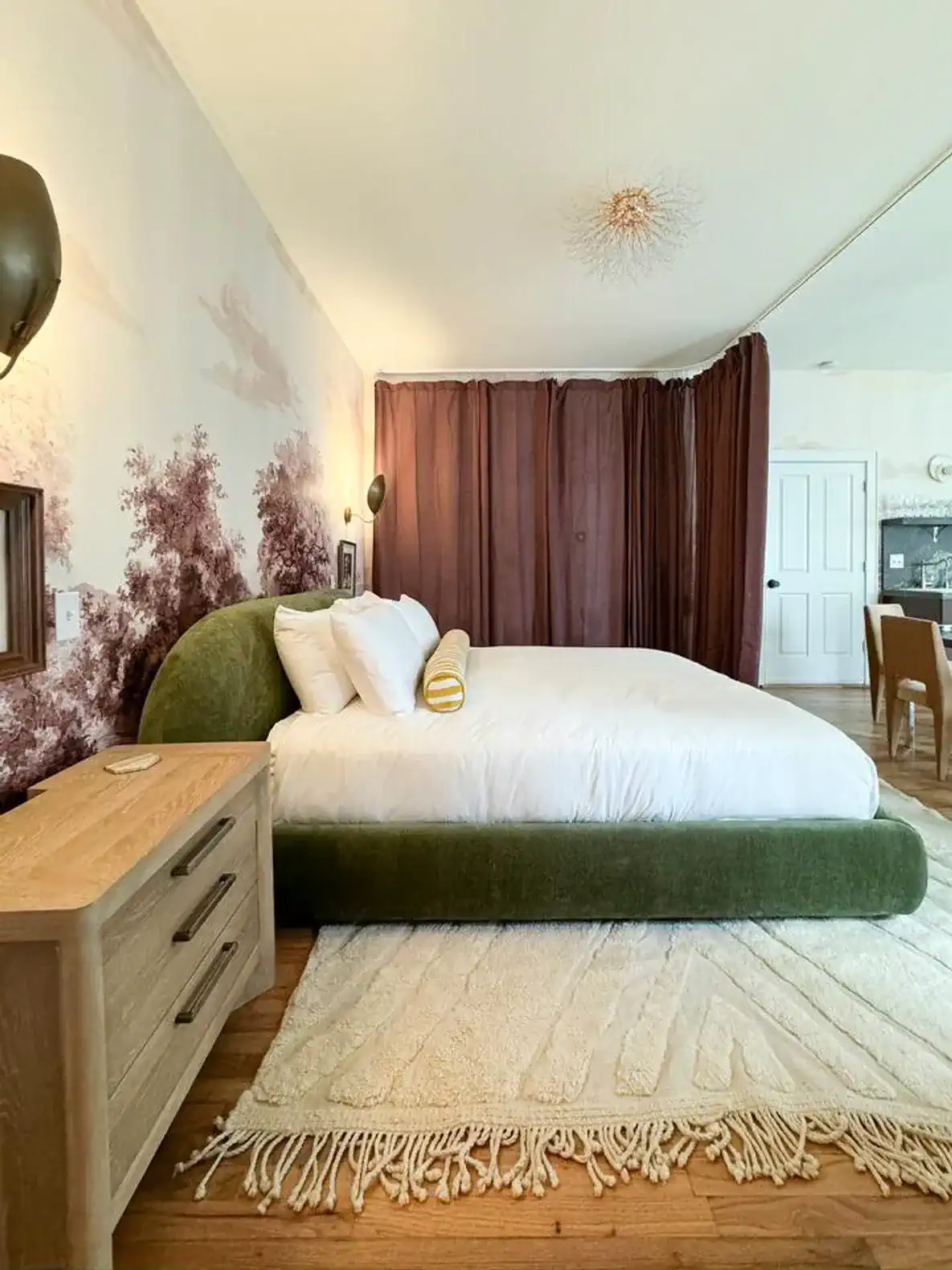 Stylish master bedroom with a green upholstered bed and elegant decor