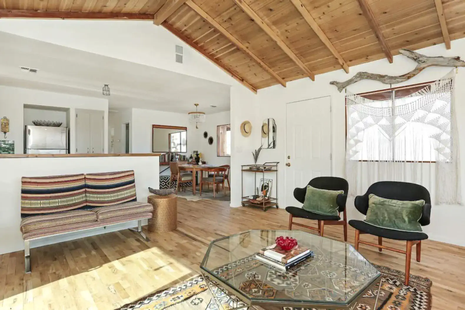 Cozy living room with wooden ceiling, stylish seating, and decorative accents
