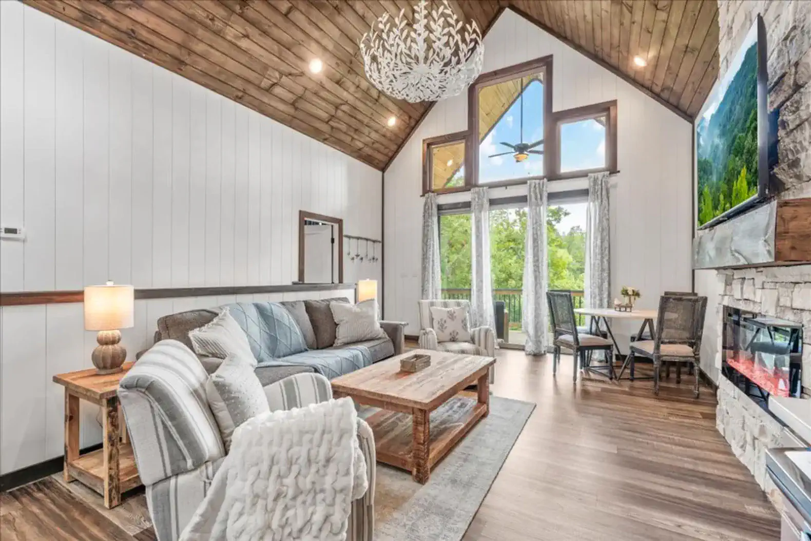 Spacious living room with high ceilings, large windows, and comfortable seating