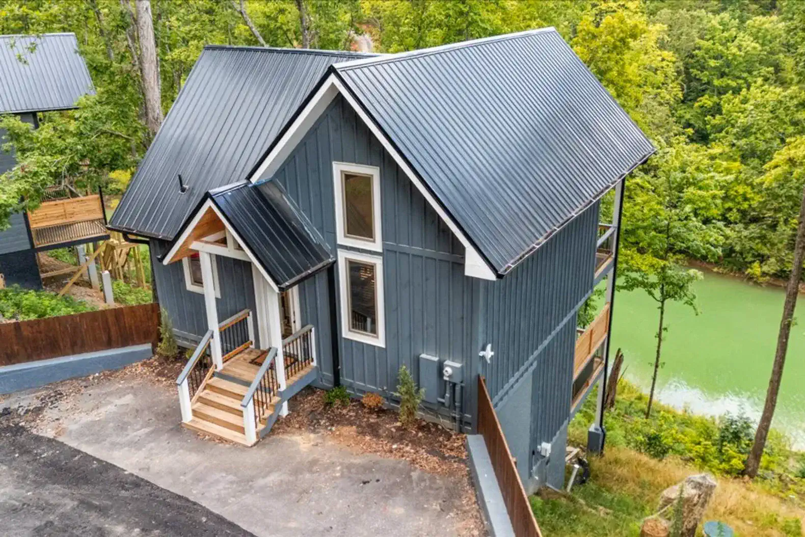 Charming exterior view of a modern cabin surrounded by trees near a lake