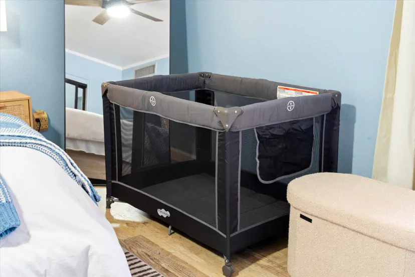 Familienfreundliches Schlafzimmer mit tragbarem Kinderbett und gemütlichem, einladendem Design