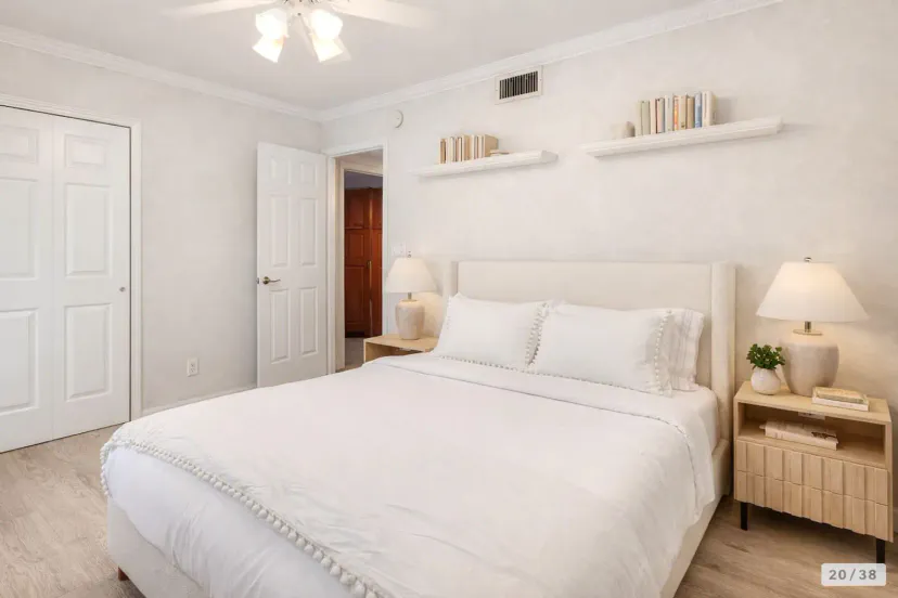 Cozy master bedroom with a queen bed, bedside tables, and decorative shelves