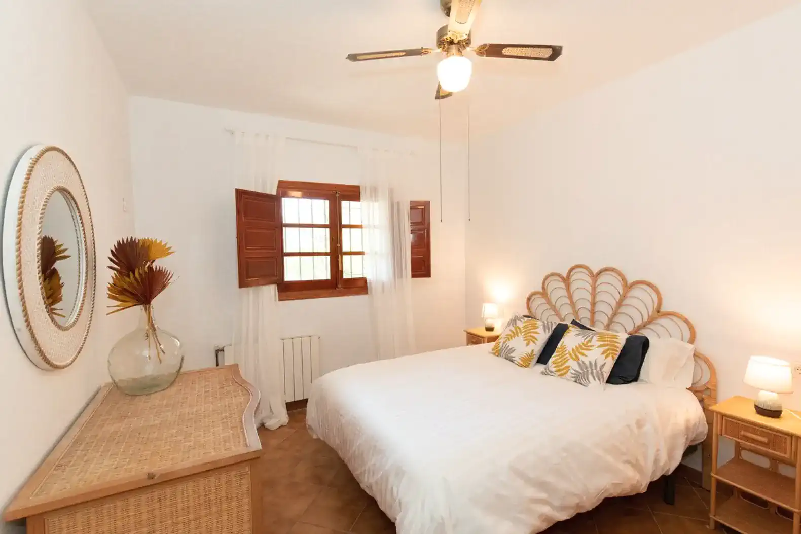 Cozy bedroom with a large bed, decorative pillows, and natural light from wooden windows