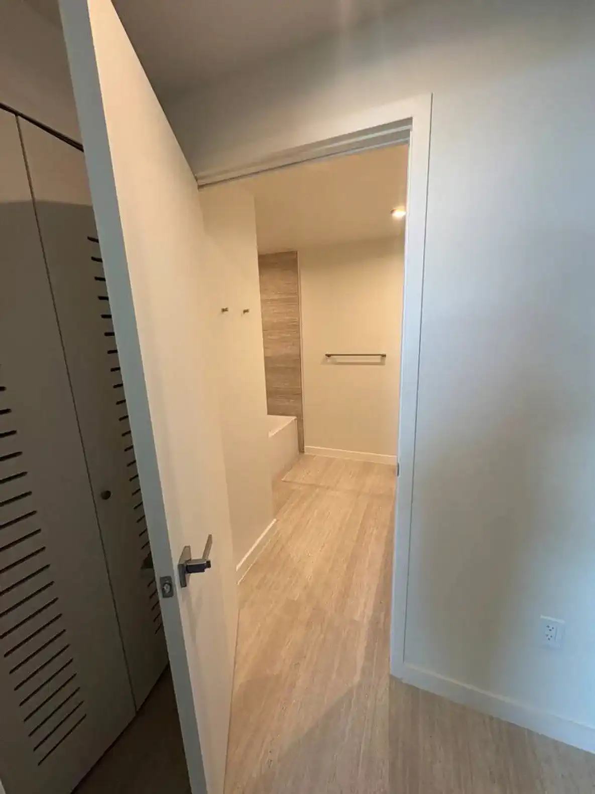 Bright and modern bathroom entrance with light-colored tiles