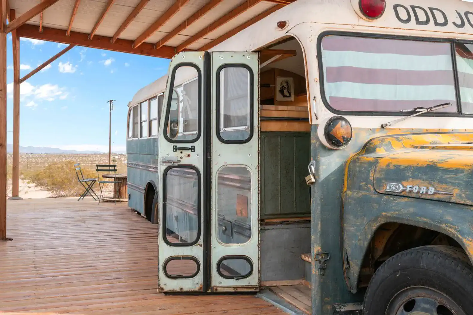 Vintage bus entrance with wooden deck and desert view