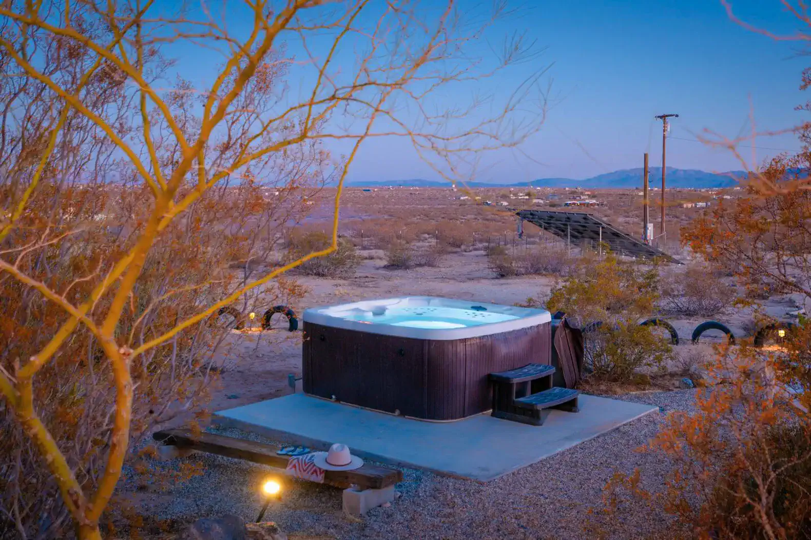 Hot tub surrounded by desert landscape and evening sky