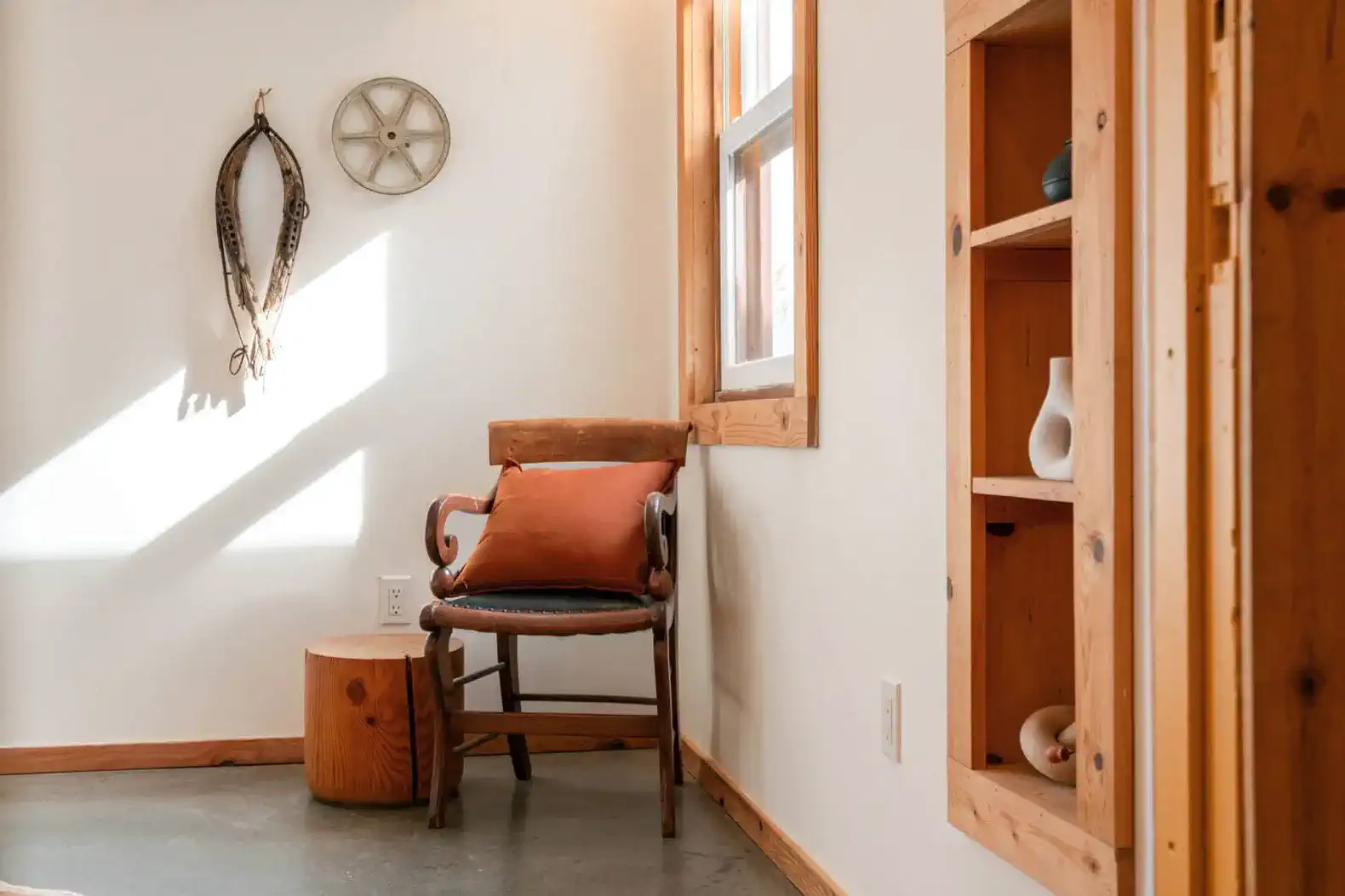 Cozy corner with a wooden chair, decorative items, and natural light