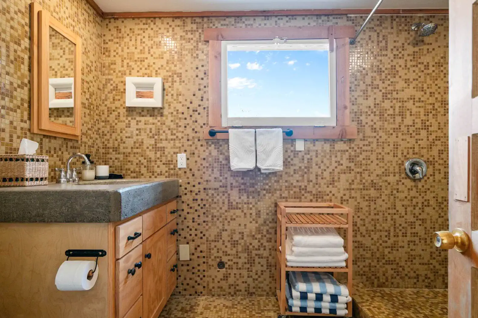 Cozy bathroom with mosaic tile walls, wooden accents, and natural light from a window
