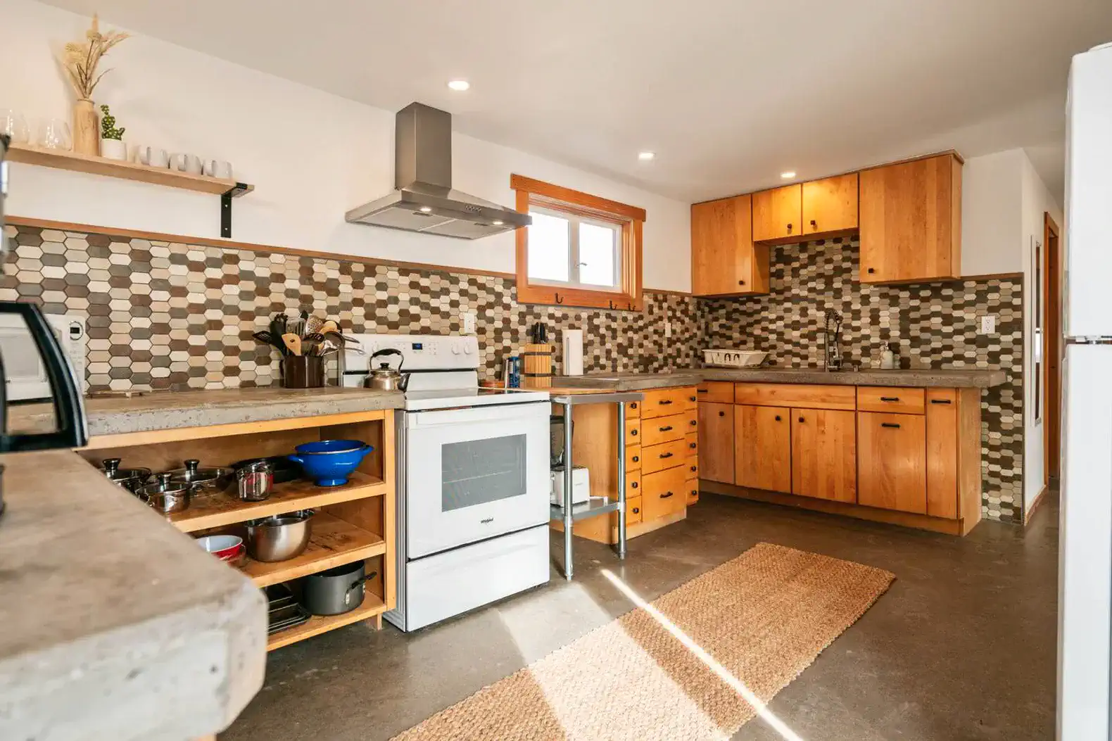 Modern kitchen with wooden cabinets, tiled backsplash, and stainless steel appliances